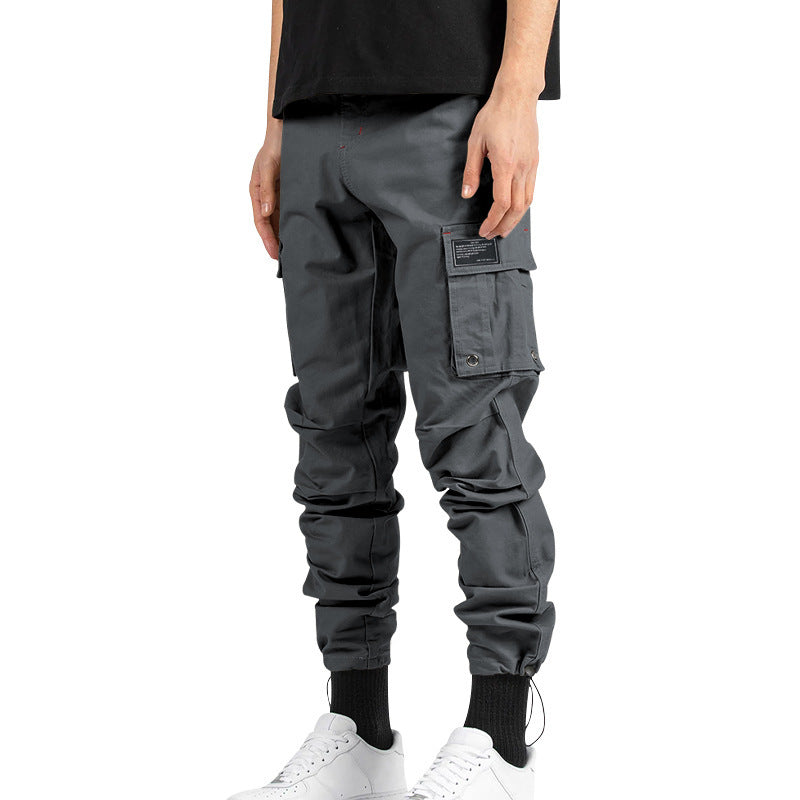 Pantalones cargo holgados de color liso con múltiples bolsillos y puños con cordón ajustable.