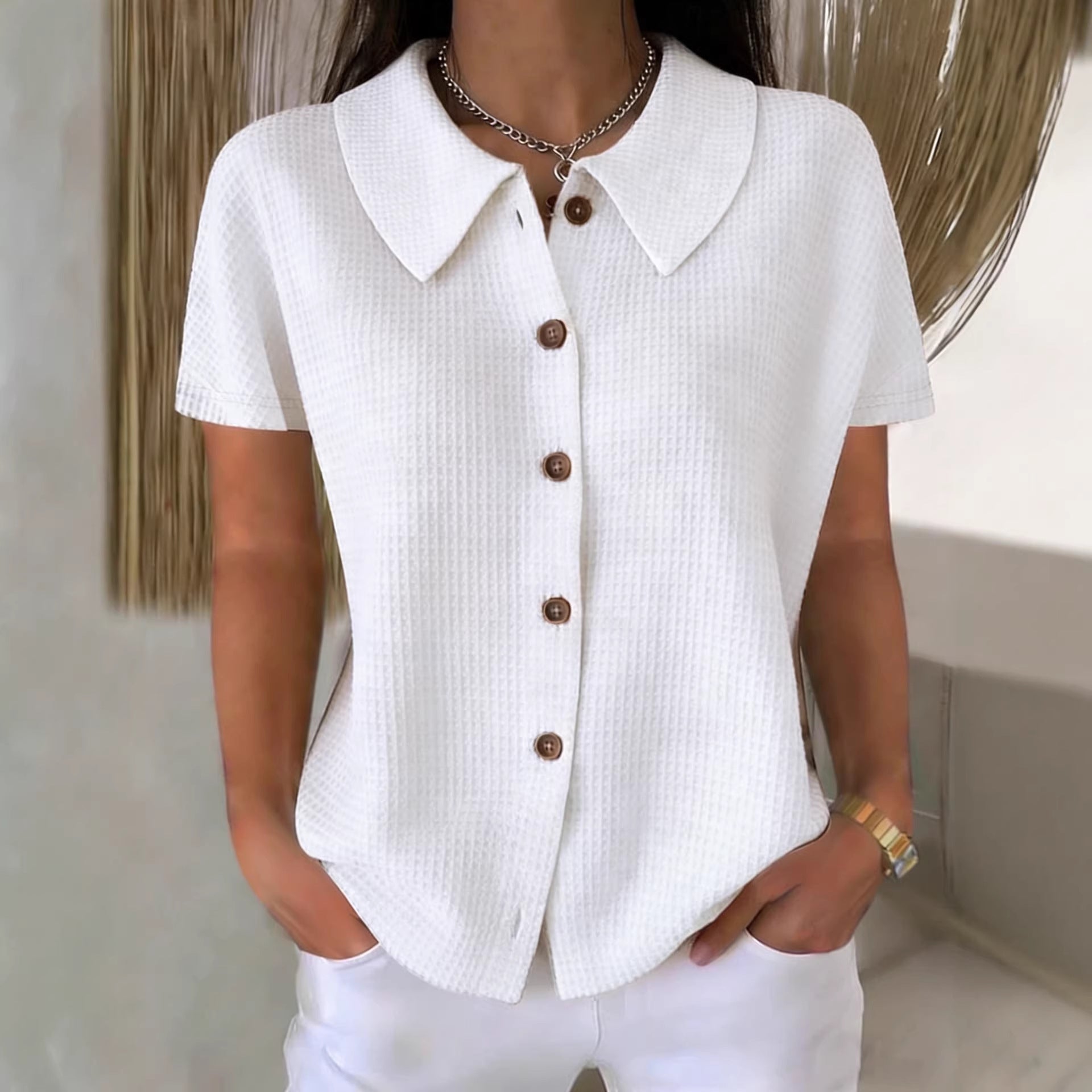 Camisa informal de manga corta, color liso, corte holgado, con cuello vuelto y tejido gofrado.