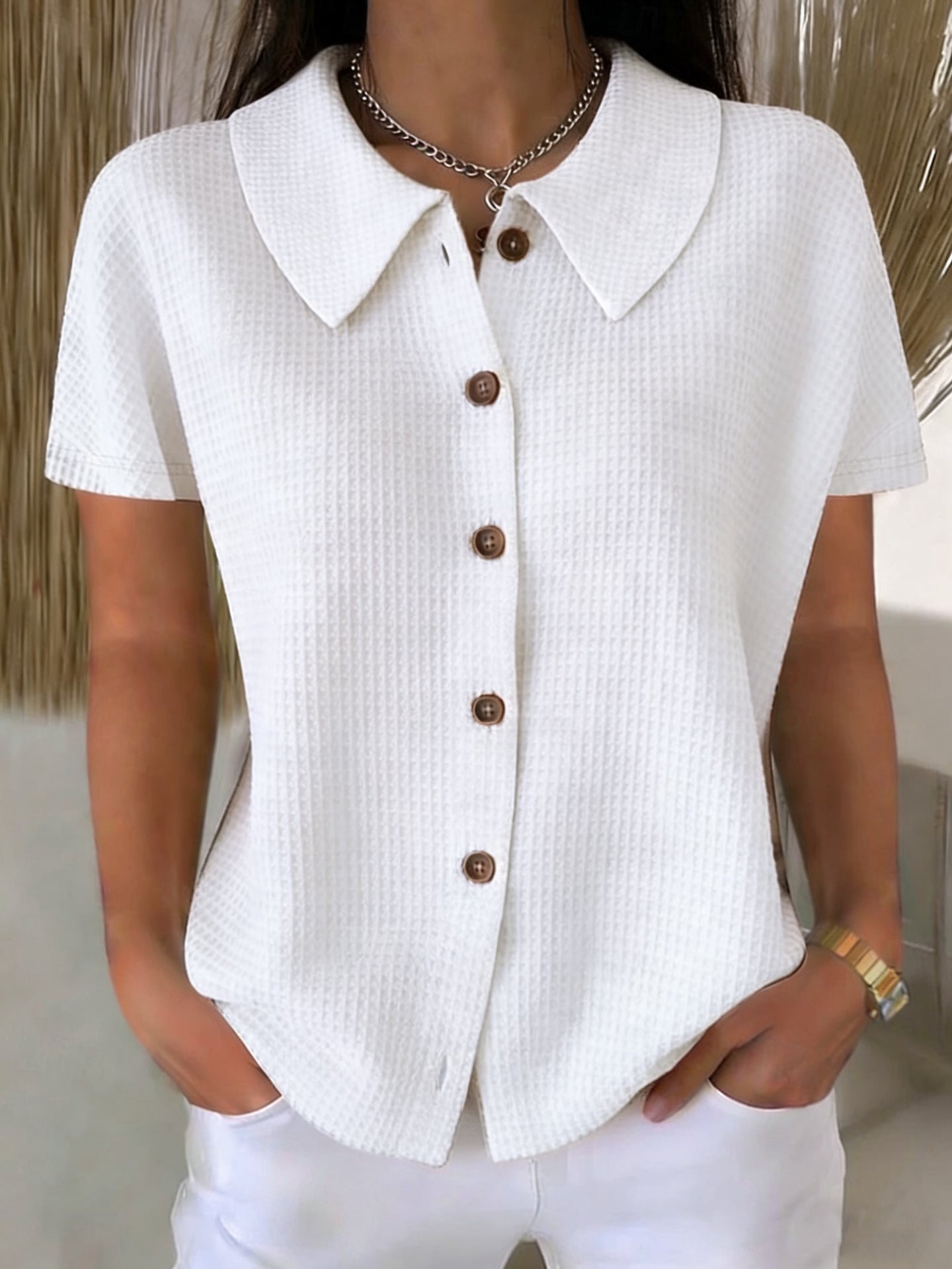 Camisa informal de manga corta, color liso, corte holgado, con cuello vuelto y tejido gofrado.