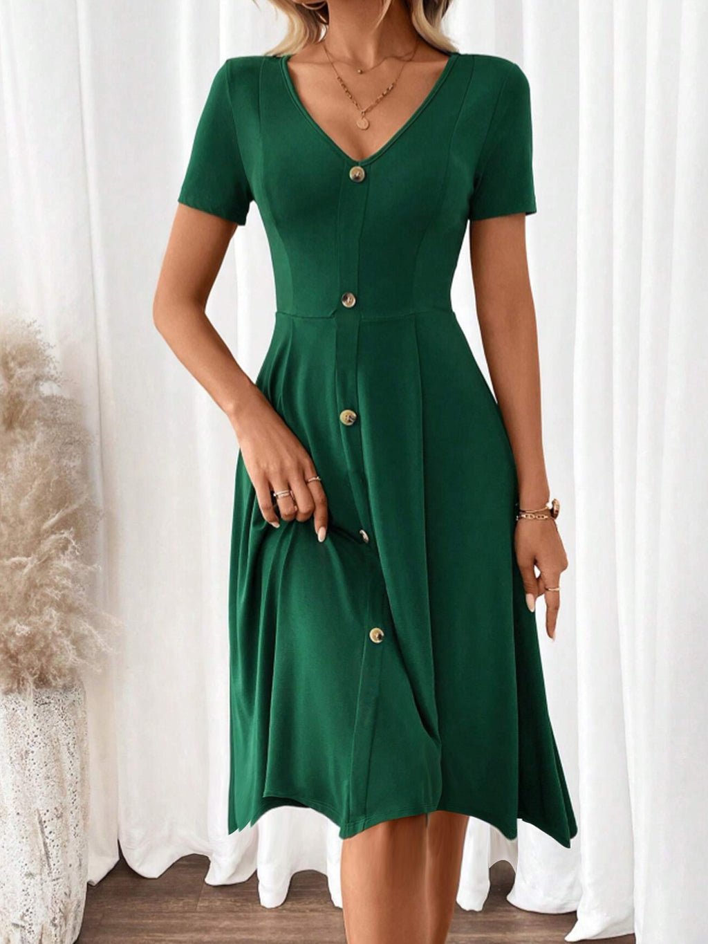 Elegante y moderno vestido de una pieza verde oscuro para mujer.