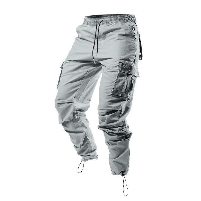 Pantalones cargo holgados de color liso con múltiples bolsillos y puños con cordón ajustable.
