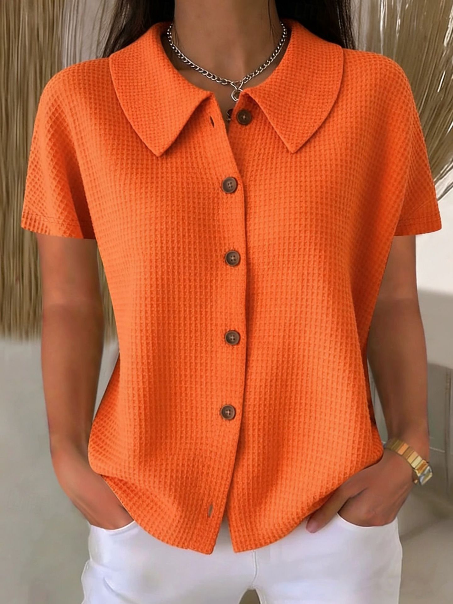 Camisa informal de manga corta, color liso, corte holgado, con cuello vuelto y tejido gofrado.
