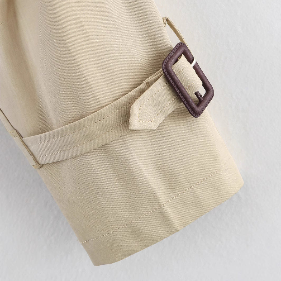 Gabardina corta para mujer con cuello de solapa y detalle de hebilla de cinturón.