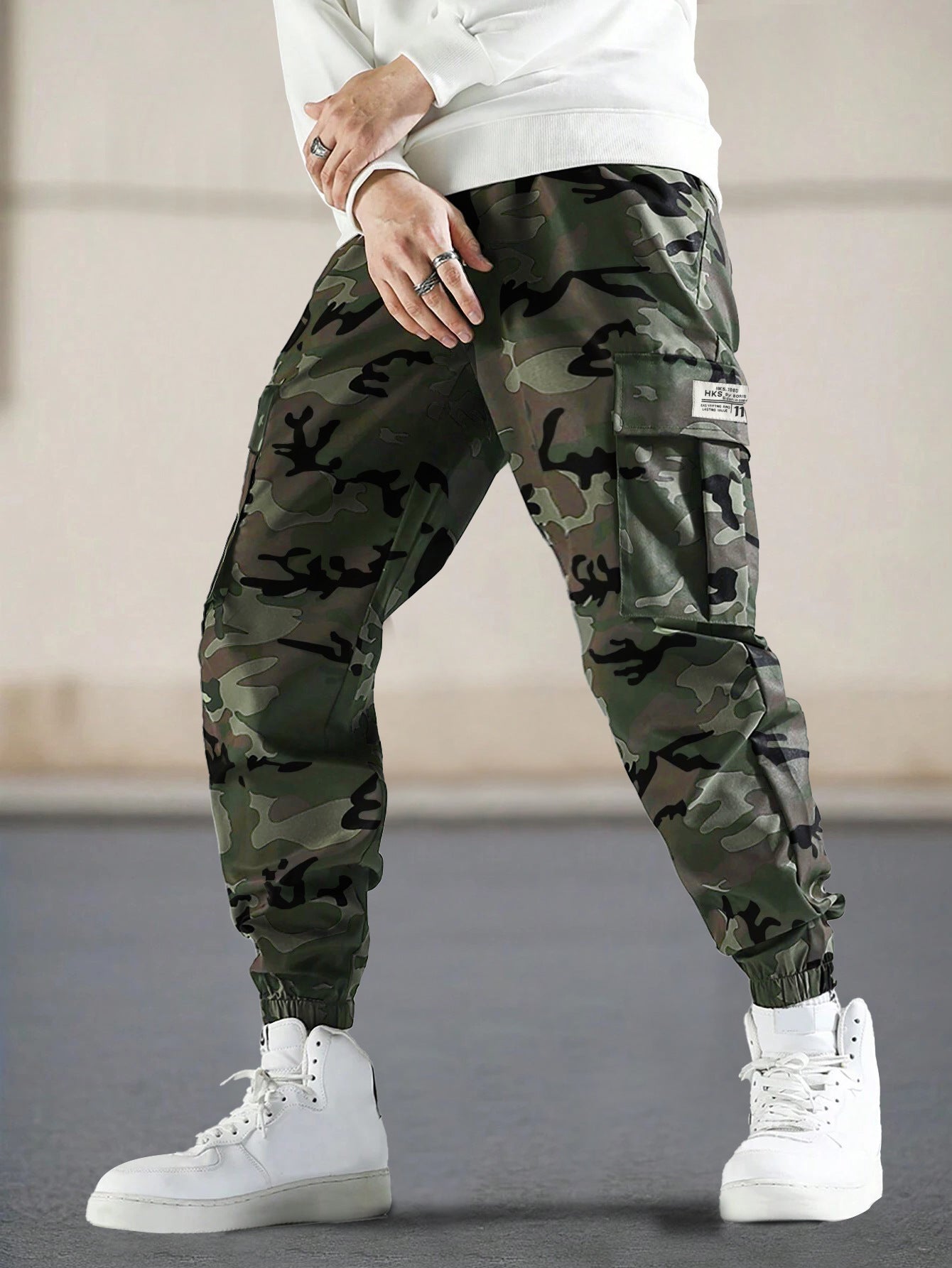 Pantalones de camuflaje para hombre con bolsillos laterales, estilo casual regular.