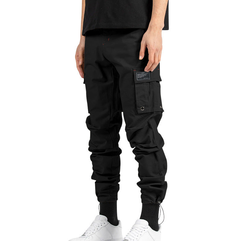 Pantalones cargo holgados de color liso con múltiples bolsillos y puños con cordón ajustable.