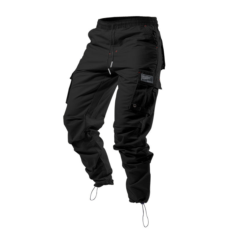 Pantalones cargo holgados de color liso con múltiples bolsillos y puños con cordón ajustable.